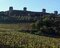 ...tra geometrici filari di viti e oliveti ben curati, mi ritrovo sotto le possenti mura turrite di Monteriggioni...